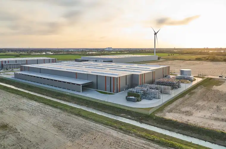 Luftaufnahme der Lagerhalle Hansalinie Bremen - Linde + Wiemann. Dargestellt sind zwei große Lagerhallen mit verschiedenen Materialien, die davor gestapelt sind.
